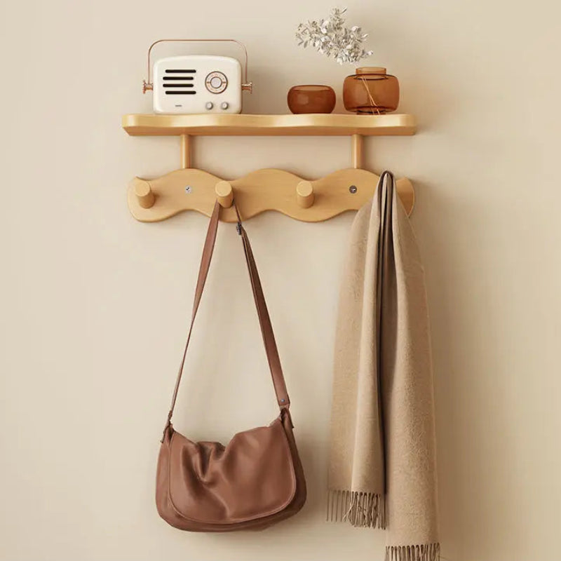 Wooden wall hook with a bag and scarf on a beige wall