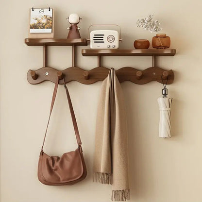 Wooden wall-mounted rack with hooks and shelves against a beige wall.