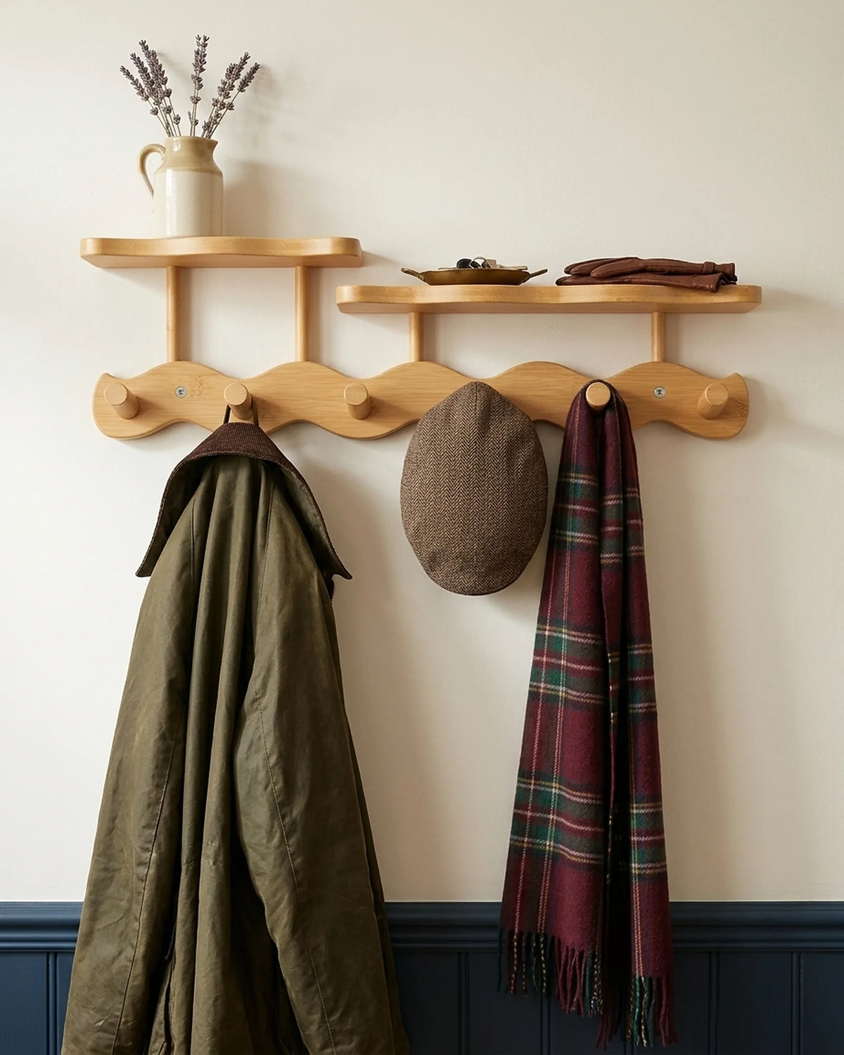 Natural bamboo wavy coat rack with two shelves holding a waxed jacket, a tweed flat cap and a tartan scarf in an Edwardian hallway