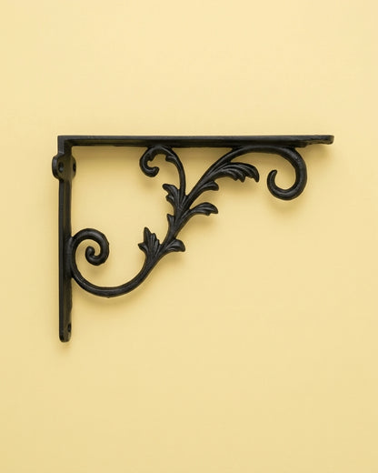 Spear Lace black cast iron shelf bracket with a fleur-de-lis on a soft pastel blush pink background